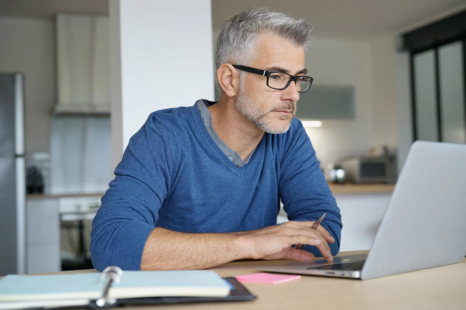 Hombre mayor realiza trabajo de forma remota en su laptop