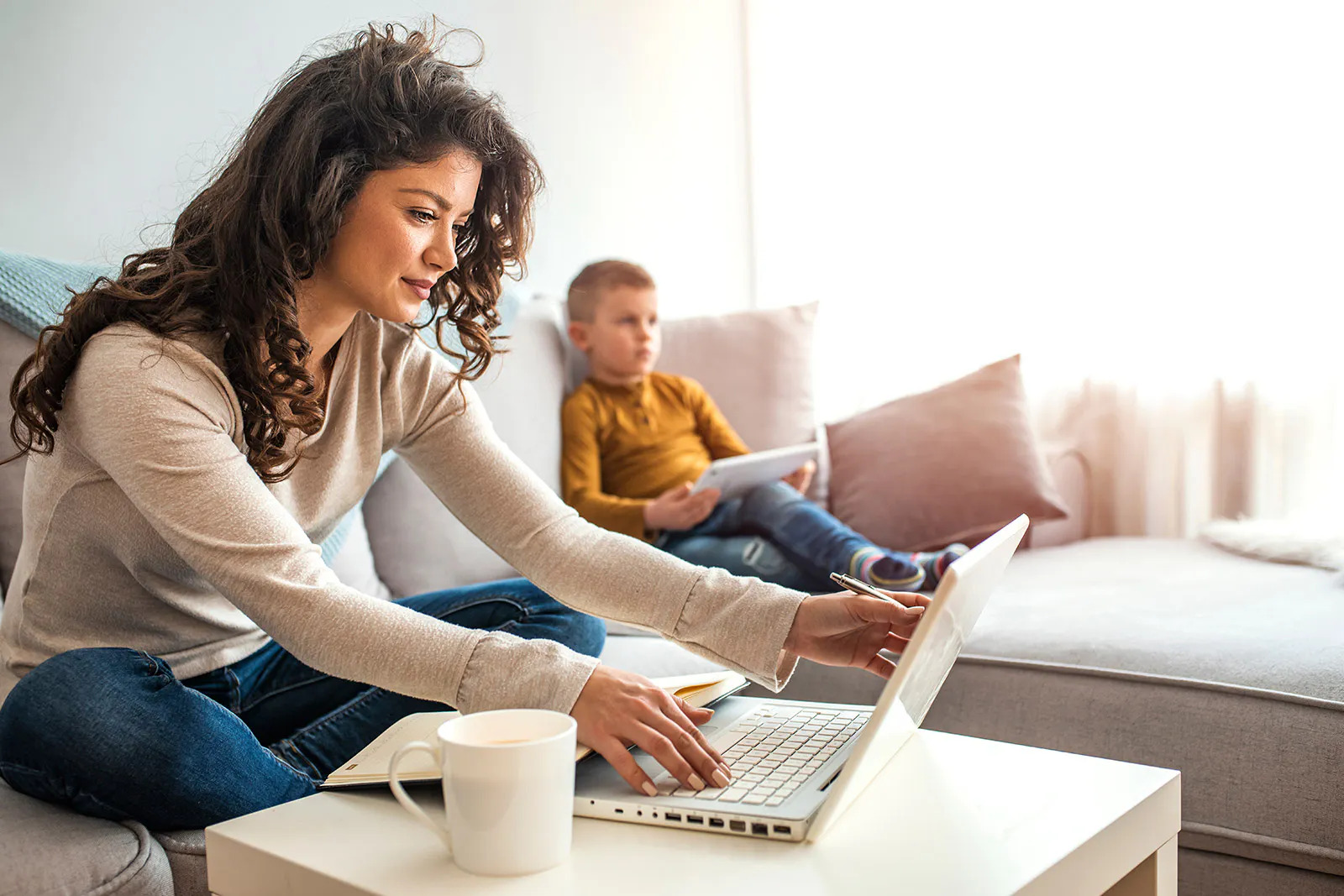 mujer realiza trabajo remoto desde la sala de su casa con su laptop